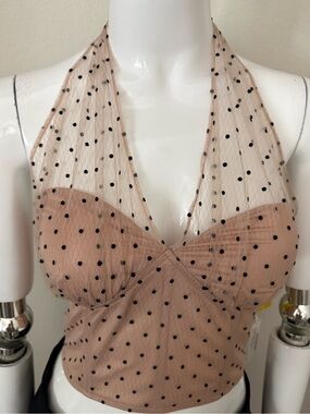 Bao Zong Black polka dot halter crop top on a nude background.